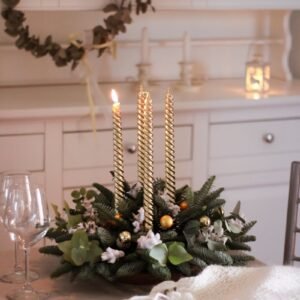 Cozy Christmas setting with festive candles and greenery on a table, ideal for holiday decor inspiration.